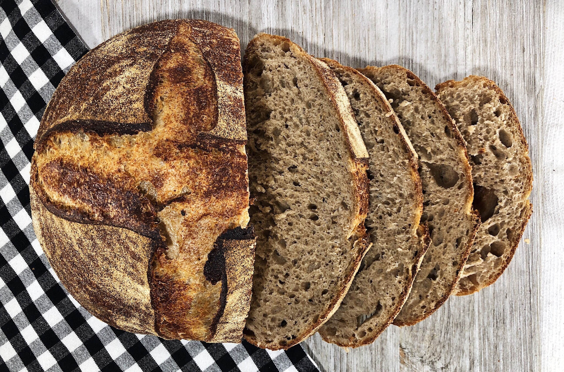 [GRIZZLY BREAD IMAGE] – round wheat sourdough loaf on linen